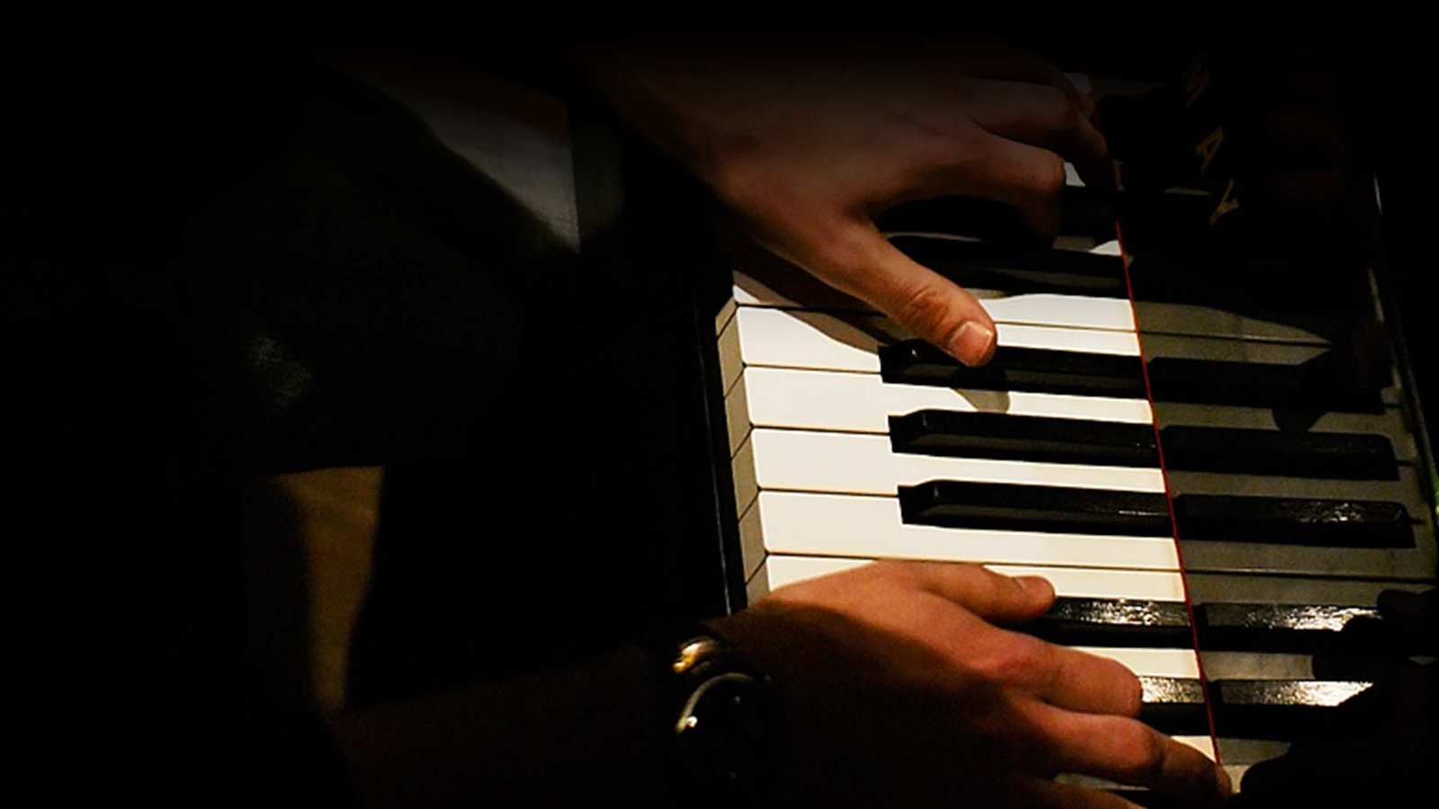 Mãos a tocar piano em ambiente de estúdio